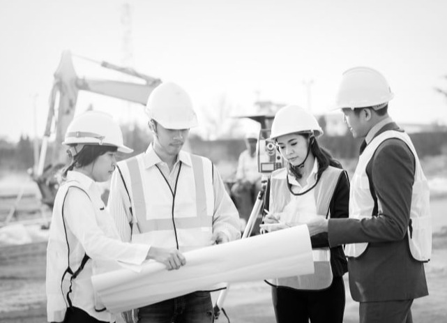 Team di tecnici in cantiere durante la consultazione degli elaborati di progetto